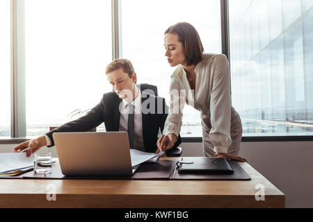 Des collègues de plus de l'affichage des documents de contrat dans le bureau. Deux professionnels qui travaillent ensemble sur des documents. Banque D'Images