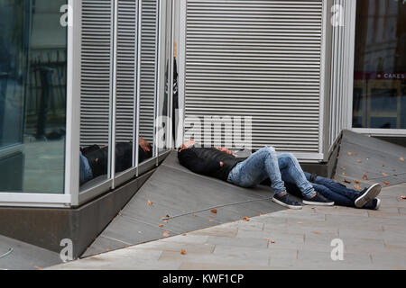 Deux hommes sans-abri dormant dehors sur un pret café à Londres, Royaume-Uni. Banque D'Images