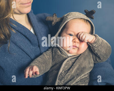 Une jeune mère est tenant son bébé portant un costume de renne Banque D'Images