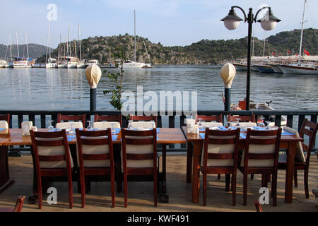 Tables et chaises en bois sur la côte en Uchagiz, Turquie Banque D'Images