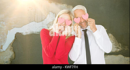 Image composite de silly couple holding cœurs sur les yeux Banque D'Images