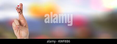 Les doigts de la Saint-Valentin aiment couple et coloré flou arrière-plan Banque D'Images