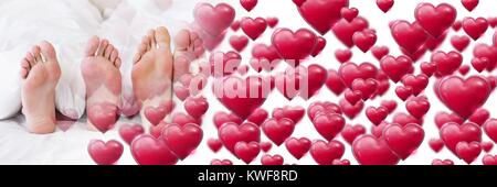 Pieds de couple dans le lit avec coeur de transition amour de Valentin Banque D'Images