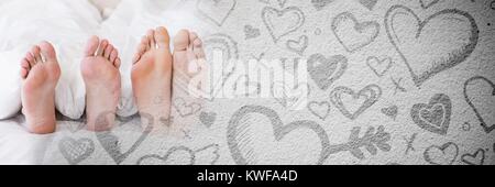 Pieds de couple dans le lit avec coeur de transition amour de Valentin Banque D'Images