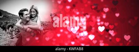 Couple donnant le pigegyback avec l'amour de la Valentin coeur de transition Banque D'Images