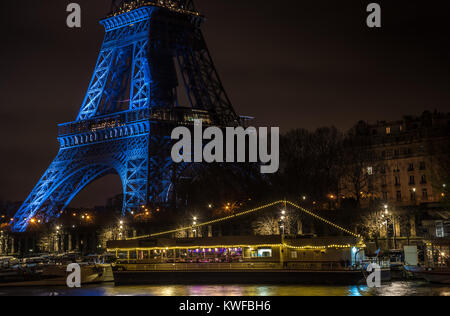 Bateau-mouche sur la Seine, vue de la tour Eiffel de nuit dans la belle ville de Paris. Cette nuit la tour Eiffel commémorait le décès de Johnny. Banque D'Images