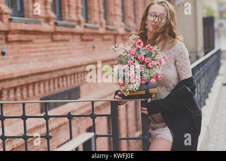 Un portrait of a Girl holding books et tulipes rouges bouquet serré Banque D'Images