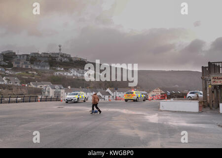 Portreath, Cornwall, UK. 3 janvier, 2018. Météo britannique. Dans les premières heures du matin d'énormes vagues de houle et détruit une section de 40 pieds du mur du port à Portreath. Le mur divise le parking - qui donne sur la mer - d'une petite plage et du pub local. Encerclé de la police le parking. Crédit : Simon Maycock/Alamy Live News Banque D'Images