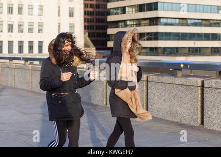 Londres, Royaume-Uni. 3 janvier, 2018. Deux jeunes femmes lutte dans le vent sur le pont de Londres. Bien que les fortes pluies ont cessé pour l'instant, les restes de la tempête Eleanor continuent à peine les Londoniens comme de fortes rafales de vent envoyer hair flying, avec des vents particulièrement imprévisibles sur les ponts sur la Tamise dans le centre de Londres. Credit : Imageplotter News et Sports/Alamy Live News Banque D'Images