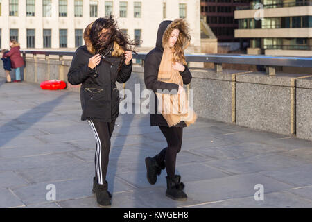 Londres, Royaume-Uni. 3 janvier, 2018. Deux jeunes femmes lutte dans le vent sur le pont de Londres. Bien que les fortes pluies ont cessé pour l'instant, les restes de la tempête Eleanor continuent à peine les Londoniens comme de fortes rafales de vent envoyer hair flying, avec des vents particulièrement imprévisibles sur les ponts sur la Tamise dans le centre de Londres. Credit : Imageplotter News et Sports/Alamy Live News Banque D'Images