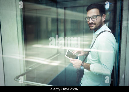 Handsome young businessman using his digital tablet Banque D'Images