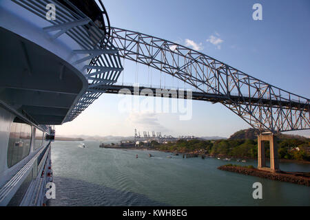 Bateau de croisière qui passe sous le Pont des Amériques, avec un important port d'expédition dans l'arrière-plan, Canal de Panama. Banque D'Images