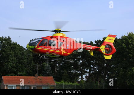 Midlands Air Ambulance en arrivant sur le village vert dans Fernhill Heath le Worcestershire à assister à une situation d'urgence. Banque D'Images