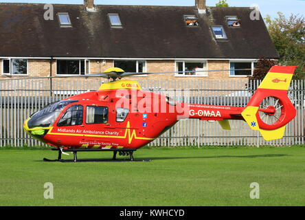 Midlands Air Ambulance en arrivant sur le village vert dans Fernhill Heath le Worcestershire à assister à une situation d'urgence. Banque D'Images