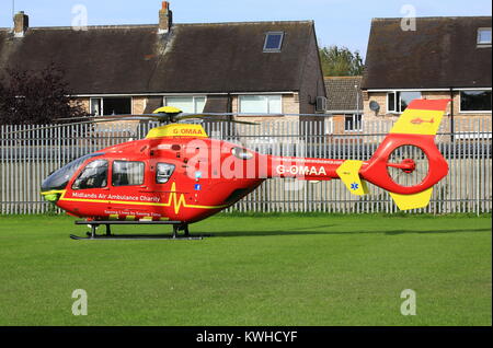 Midlands Air Ambulance en arrivant sur le village vert dans Fernhill Heath le Worcestershire à assister à une situation d'urgence. Banque D'Images