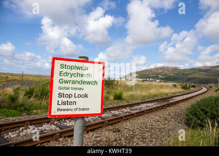 Arrêter de regarder écouter panneau d'avertissement avec rail track, Barmouth à distance au Nord du Pays de Galles UK Banque D'Images