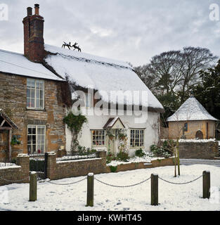 Chaumière dans la neige en décembre. South Littleton, Worcestershire, Angleterre. Banque D'Images