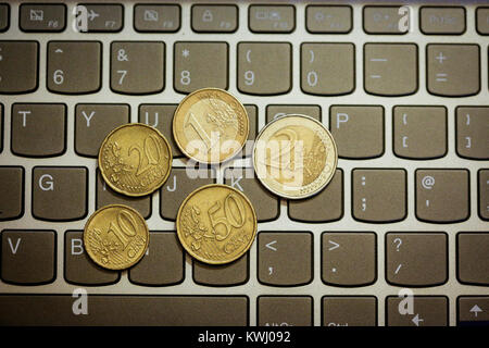 Pièces en euro sur le clavier de l'ordinateur portable - faire de l'argent en ligne Banque D'Images