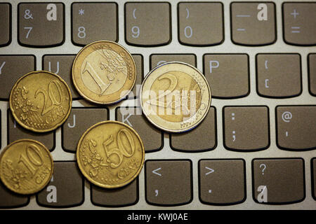 Pièces en euro sur le clavier de l'ordinateur portable - faire de l'argent en ligne Banque D'Images