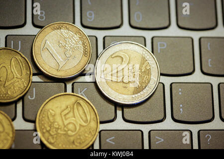 Pièces en euro sur le clavier de l'ordinateur portable - faire de l'argent en ligne Banque D'Images