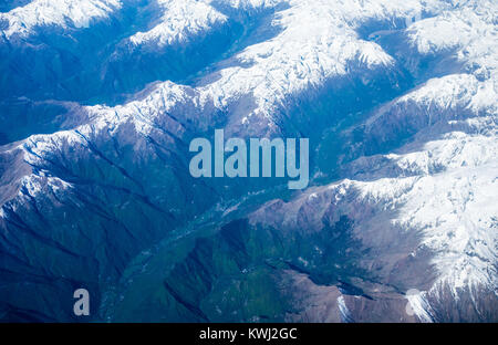 Vue aérienne de montagnes enneigées et de vallées verdoyantes dans les Alpes européennes au cours de l'été. Banque D'Images