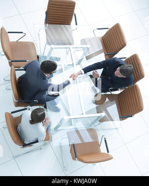 Poignée de l'autre côté de la table. Rencontre autour d'une table de conférence. Banque D'Images