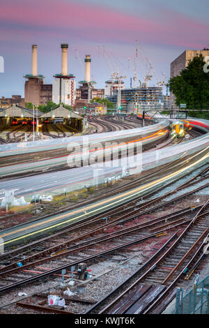 Battersea Powerstation avec trois cheminées vus de près de Victoria Station. Un train se déplace au cours de cette longue soirée exposition Banque D'Images