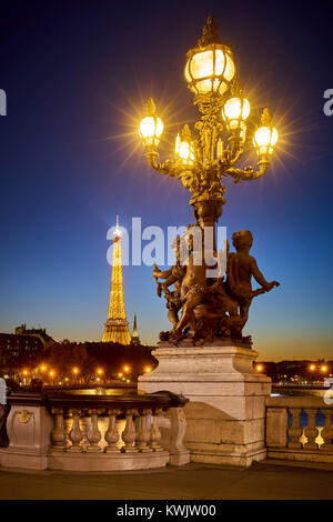 Pont Alexandre III pont style candélabre lampadaire avec la Tour Eiffel illuminée. 8ème arrondissement, Rive Droite, Paris, France Banque D'Images