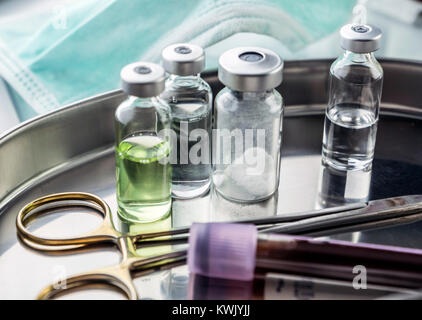 Les ciseaux et les flacons d'échantillons de sang dans un bac sur une table d'un hôpital, conceptual image Banque D'Images