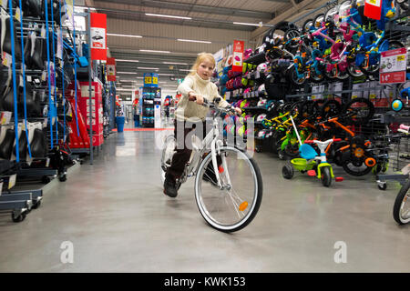 Jeune fille rider âgés de 7 ans rides / riders prendre des vélos / Nouveau / location de cycles pour un cycle de test à un bike shop avant d'acheter, en vacances. (93) Banque D'Images