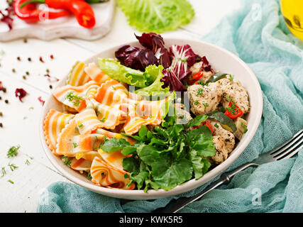 Une bonne nutrition. Salade diététique. Pâtes Farfalle le blé avec filet de poulet au four avec l'aubergine, la courgette et de la salade dans un bol. Banque D'Images