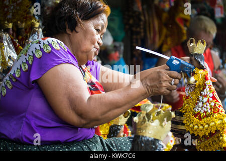 Street Vendor réparant une statue religieuse d'un Santo Nino, enfant Jésus figurine, Cebu City, Philippines Banque D'Images