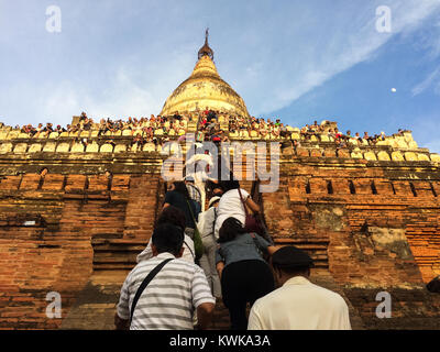 Les touristes grimper dans la célèbre pagode à Pyathadar Hpaya pour Bagan Myanmar coucher du soleil près de Mandalay Banque D'Images