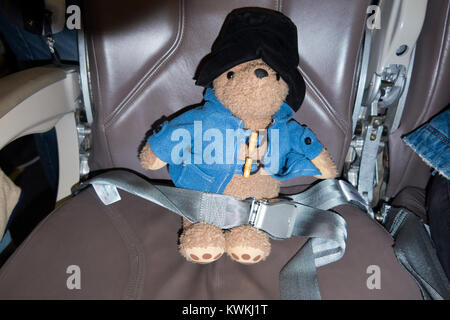 Childs doudou, l'ours Paddington, perdu peut-être passager, assis dans un avion en avion / air / siège d'avion destiné à un tarif passager payant. Banque D'Images
