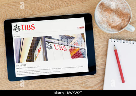 La Banque UBS Site sur un iPad tablet device, reposant sur une table en bois à côté d'un bloc-notes, crayon et tasse de café (rédaction uniquement) Banque D'Images