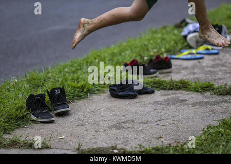 Davenport, Iowa, États-Unis. 24 juillet, 2017. Guterrez, Ricky, 8 sauts de l'herbe pour s'écouler dans le jet d'eau tandis que dehors avec l'Organisation des voisins Parc d'été Programme au Cork Hill Park à Davenport le lundi, 24 juillet 2017. Davenport et incendie départements parcs font équipe pour visiter plusieurs quartiers et fournir une occasion pour les enfants et les adultes pour se rafraîchir dans l'eau dans le cadre de la ''Combattre la chaleur'' initiative qui a été mise en place depuis un certain nombre d'années. Credit : Andy Abeyta, Quad-City Times/Quad-City Times/ZUMA/Alamy Fil Live News Banque D'Images