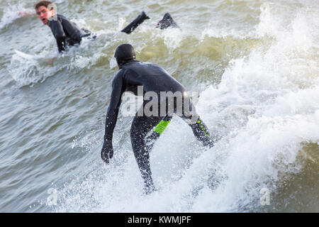 Bournemouth, Dorset, England UK. 4 janvier, 2018. Météo France : surfer une vague profitant du surf sur un jour de vent à la plage de Bournemouth, que les surfeurs profiter de la vent et de grosses vagues. Banque D'Images