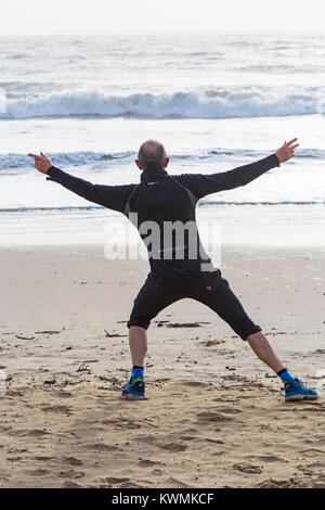 Bournemouth, Dorset, UK. 4 janvier, 2018. Météo France : Jour de vent à Bournemouth. Man doing tai chi sur la plage Banque D'Images