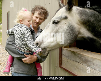 Dallas Center, Iowa, États-Unis. 21 mai, 2017. Curtis Fry détient sa fille Avery 2, tout en disant bonjour à Simon le cheval, dimanche 21 mai 2017, sur leur ferme de Dallas Center, Iowa. Crédit : John Schultz/Quad-City Times/ZUMA/Alamy Fil Live News Banque D'Images