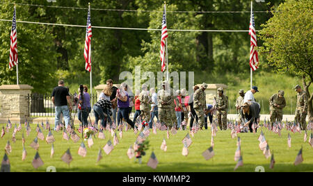 Rock Island Arsenal, Iowa, États-Unis. 25 mai, 2017. Certains des 350 bénévoles aidant à placer les drapeaux sur les marqueurs, jeudi, 25 mai 2017, au cours de l'assemblée annuelle de l'événement à l'emplacement du drapeau National Cemetery sur le Rock Island Arsenal. Crédit : John Schultz/Quad-City Times/ZUMA/Alamy Fil Live News Banque D'Images