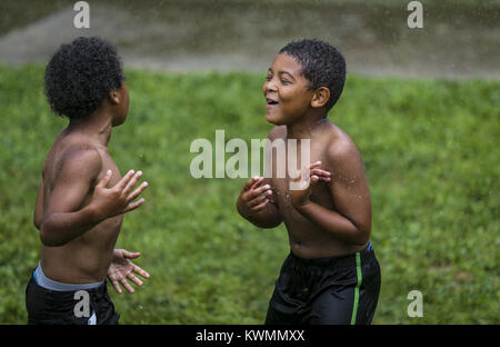 Davenport, Iowa, États-Unis. 24 juillet, 2017. Savion Donelson, 9, danse avec un autre garçon, tout en jouant avec l'Organisation des voisins Parc d'été groupe programme à la Cork Hill Park à Davenport le lundi, Juillet 24, 2017. Davenport et incendie départements parcs font équipe pour visiter plusieurs quartiers et fournir une occasion pour les enfants et les adultes pour se rafraîchir dans l'eau dans le cadre de la ''Combattre la chaleur'' initiative qui a été mise en place depuis un certain nombre d'années. Credit : Andy Abeyta, Quad-City Times/Quad-City Times/ZUMA/Alamy Fil Live News Banque D'Images