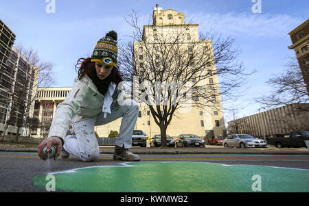 Davenport, Iowa, États-Unis. Mar 12, 2017. Justine Goulder de Bettendorf peintures par pulvérisation d'un contour blanc sur un shamrock sur la 2e Rue à Davenport le Dimanche, Mars 12, 2017. Peintres de la section locale 676 & 502 Programme d'apprentissage des trèfles peints peintres dans la rue le long de la ligne de départ du 35e centre pour aînés actifs le jour de la Saint Patrick la race. Credit : Andy Abeyta/Quad-City Times/ZUMA/Alamy Fil Live News Banque D'Images