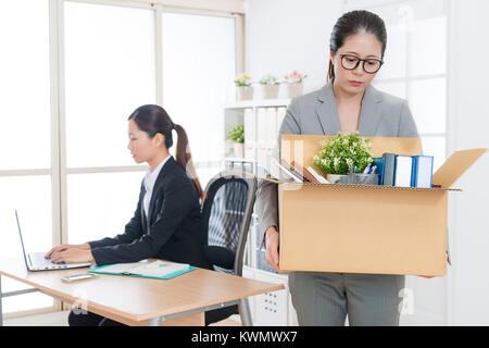 Belle jeune femme d'affaires est tiré et holding box laissant company. Banque D'Images