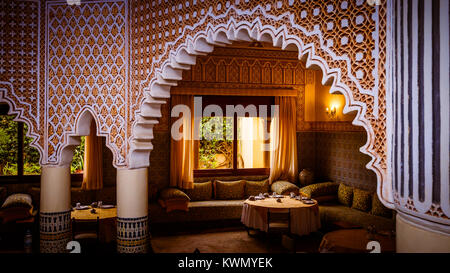 Les tables d'un intérieur lumineux arabe traditionnel avec des colonnes, des arches et des motifs décoratifs Banque D'Images