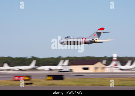 Mig 17 effectue un vol à grande vitesse par le NAS Jacksonville 2017 Airshow avec P-8 à l'arrière-plan. Banque D'Images