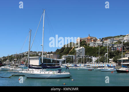 Clyde Marina Quay, Oriental Bay, le port de Wellington, Wellington, Nouvelle-Zélande avec St Gerard's couvent et l'Église sur la colline au-dessus de boatsheds. Banque D'Images