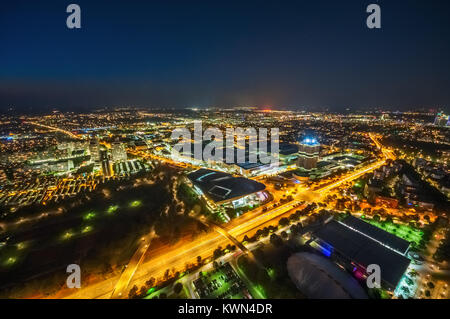 Vue aérienne du Village olympique de Munich, éclairé et le siège de BMW dans la nuit. Munich, Allemagne. Banque D'Images