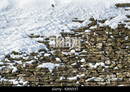 En pierre de Cotswold mur recouvert de neige. Cotswolds, Gloucestershire, Angleterre Banque D'Images