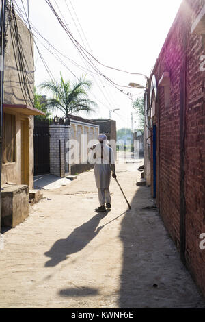 Vue arrière d'un vieux homme pakistanais marche dans une ruelle Banque D'Images