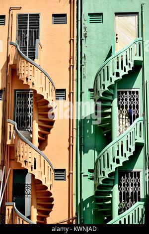 Une paire de vieilles pierres colorées escaliers en spirale à l'extérieur de maisons mitoyennes shop dans le quartier historique de Little India, à Singapour Banque D'Images